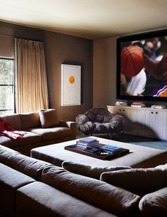 a living room filled with furniture and a flat screen tv mounted to the side of a wall