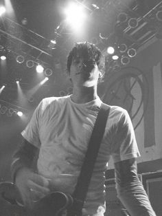 a man standing on stage holding a guitar