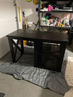 a workbench in a garage with various items on the floor