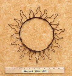 a metal sun on the wall next to a ruler