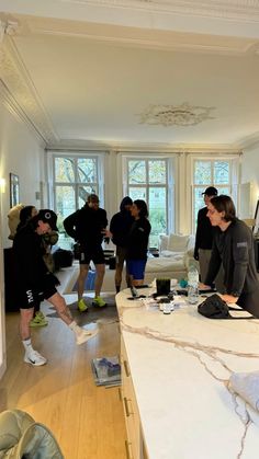 a group of people standing around a living room