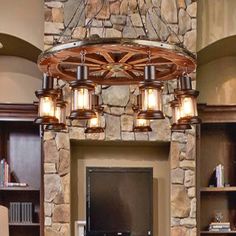 a living room filled with furniture and a flat screen tv mounted to a stone wall