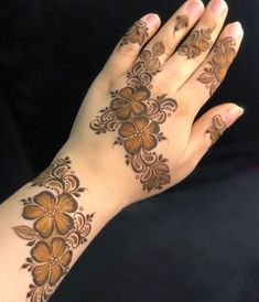 a woman's hand with henna tattoos on it