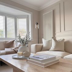 a living room filled with furniture and a book on top of a wooden coffee table