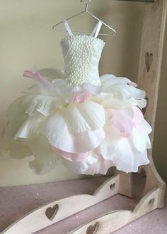 a dress hanging on a clothes rack in a room with pink and white flowers,