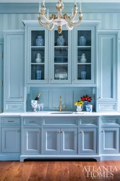 a kitchen with blue cabinets and white marble counter tops, gold trim on the doors