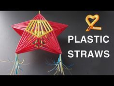 a red star hanging from the side of a wall with plastic straws attached to it