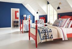 a bedroom with blue walls, white floors and red bedding in the middle of it