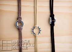 three different types of leather cords with metal rings attached to them on wooden planks