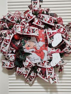 a christmas wreath hanging on the side of a building with santa claus and reindeer decorations