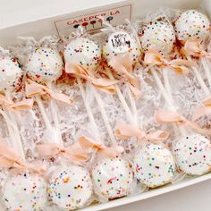 a box filled with cake pops covered in sprinkles