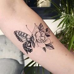 a butterfly and flower tattoo on the arm