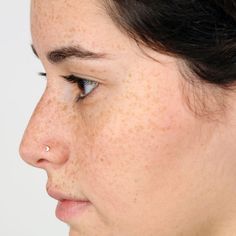 a woman with freckles on her nose looking to the side, close up