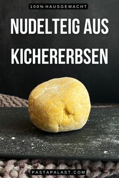 a loaf of bread sitting on top of a black surface with the words nudeletig aus kichererbsen