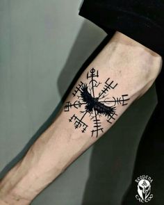 a person with a black and white tattoo on their arm that has an arrow in it