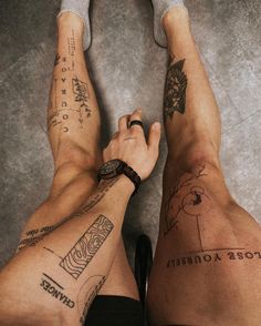 two people with tattoos on their legs and one has his hand in the other's pocket