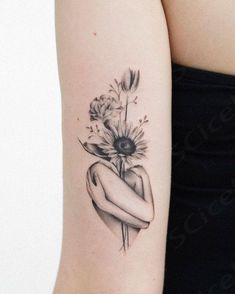 a woman's arm with a flower tattoo on the left side of her body