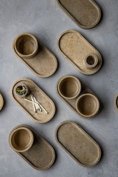 several pieces of pottery sitting on top of a table next to cups and spoons