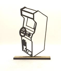 a black and white drawing of a camera on a wooden block with a ruler in front of it