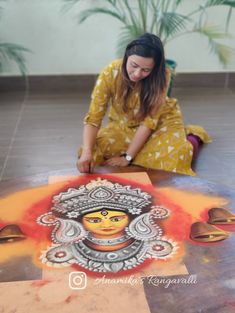 a woman sitting on the floor in front of an art work with colors and shapes