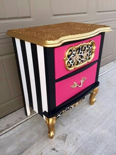 a pink and black dresser with gold accents