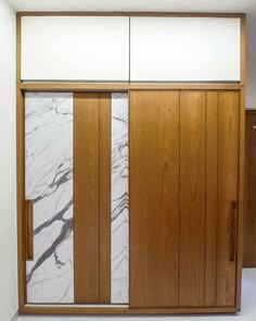 a room with wooden doors and white marble on the wall, along with wood paneling