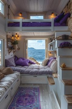 a small bedroom with purple pillows on the bed and stairs leading up to the second floor