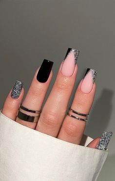 a woman's hand with black and pink manicures on her nails, holding a white bag