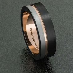 a black and gold wedding band with an inscription engraved on the side, in two tone