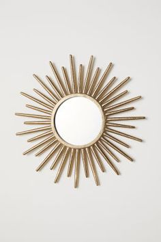 a gold sun mirror hanging on the wall