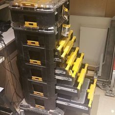 there are many black and yellow boxes stacked on top of each other in the room