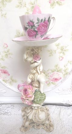 there is a cup and saucer sitting on top of each other in the shape of an angel