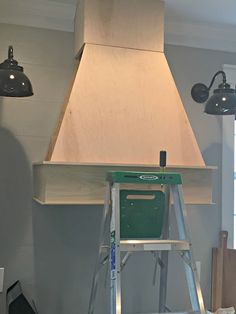 a stove that is sitting on a step ladder in a room with two lights hanging from the ceiling