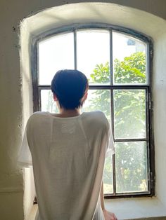 a person sitting in front of a window looking out