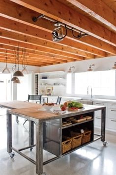 a kitchen with an island in the middle and lots of wood on the ceiling above it