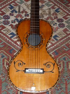 an old guitar sitting on top of a rug