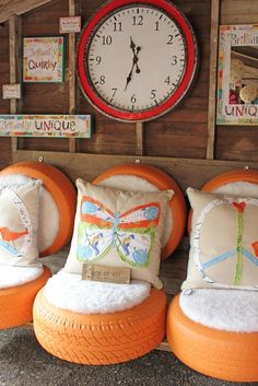 an orange chair and some pillows in front of a clock