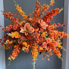 a vase filled with lots of orange flowers