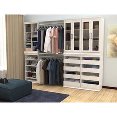 a large closet filled with lots of clothes and other items on shelves next to a couch