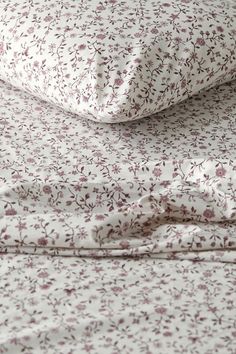 an image of a bed with floral sheets and pillow cases on top of each other