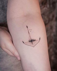 a woman's arm with an arrow tattoo on the left side of her body