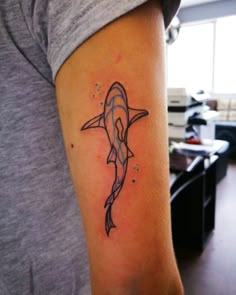 a tattoo on the arm of a woman with a dolphin in it's mouth