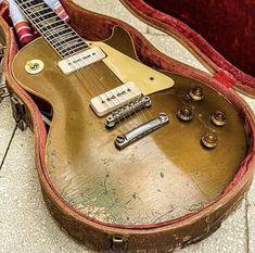 an old guitar sits in its case on the floor