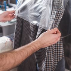 the man is wrapping his coat in plastic