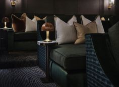 a row of couches with pillows and lamps on them