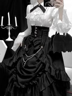 For a noble lady with gorgeous and dignified elegance. The contrast between her black and white makes her presence stand out. An elegant, voluminous skirt and an overskirt with even more volume and a high-waisted silhouette. Paired with a white blouse richly decorated with lace embroidery, her outfit is mysterious, yet dramatic and dazzling.       Item     Skirt   Overskirt   Blouse (white/red)         Size     Skirt     S size     Total length: 94cm   Waist: 70cm     M size     Total length: 94 Elegant Skirts, Voluminous Skirt, Old Fashion Dresses, Dress Design Sketches, Elegant Skirt, Gothic Outfits, Goth Outfits, Blouse White, Lace Embroidery