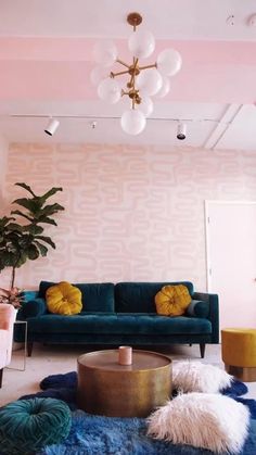 a living room with pink walls, blue couches and rugs on the floor