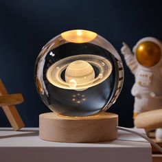 a glass globe with an image of saturn in the center on top of a wooden stand