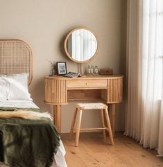 a bedroom with a bed, desk and mirror on the wall next to it's windows