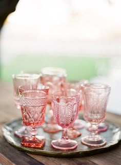 pink glasses are lined up on a tray